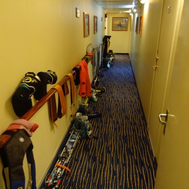 The hallway of the boat outside of the guests rooms doubles as a drying rack for ski gear