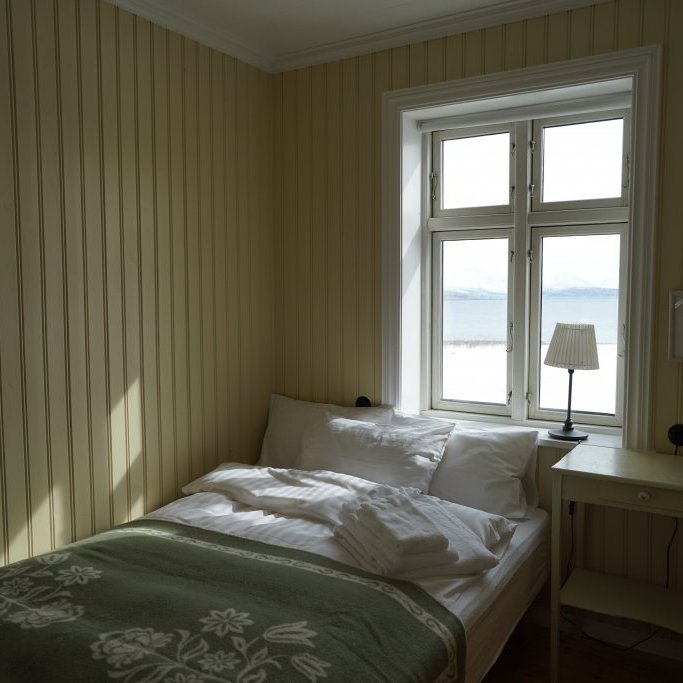 One of the two bedrooms on the main floor of Karlsá Lodge with a view out to the fjord