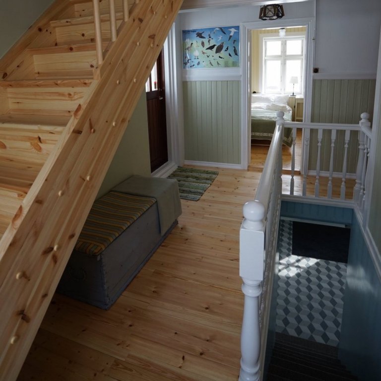 Stairs leading up to the 5 bedrooms on the top floor and down to the ground floor bathrooms and boot room area.