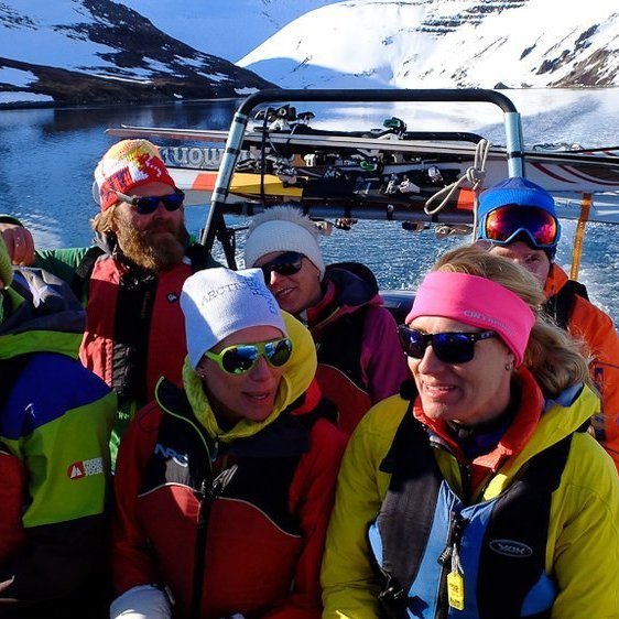 Getting a ride in the zodiac to the next ski run.
